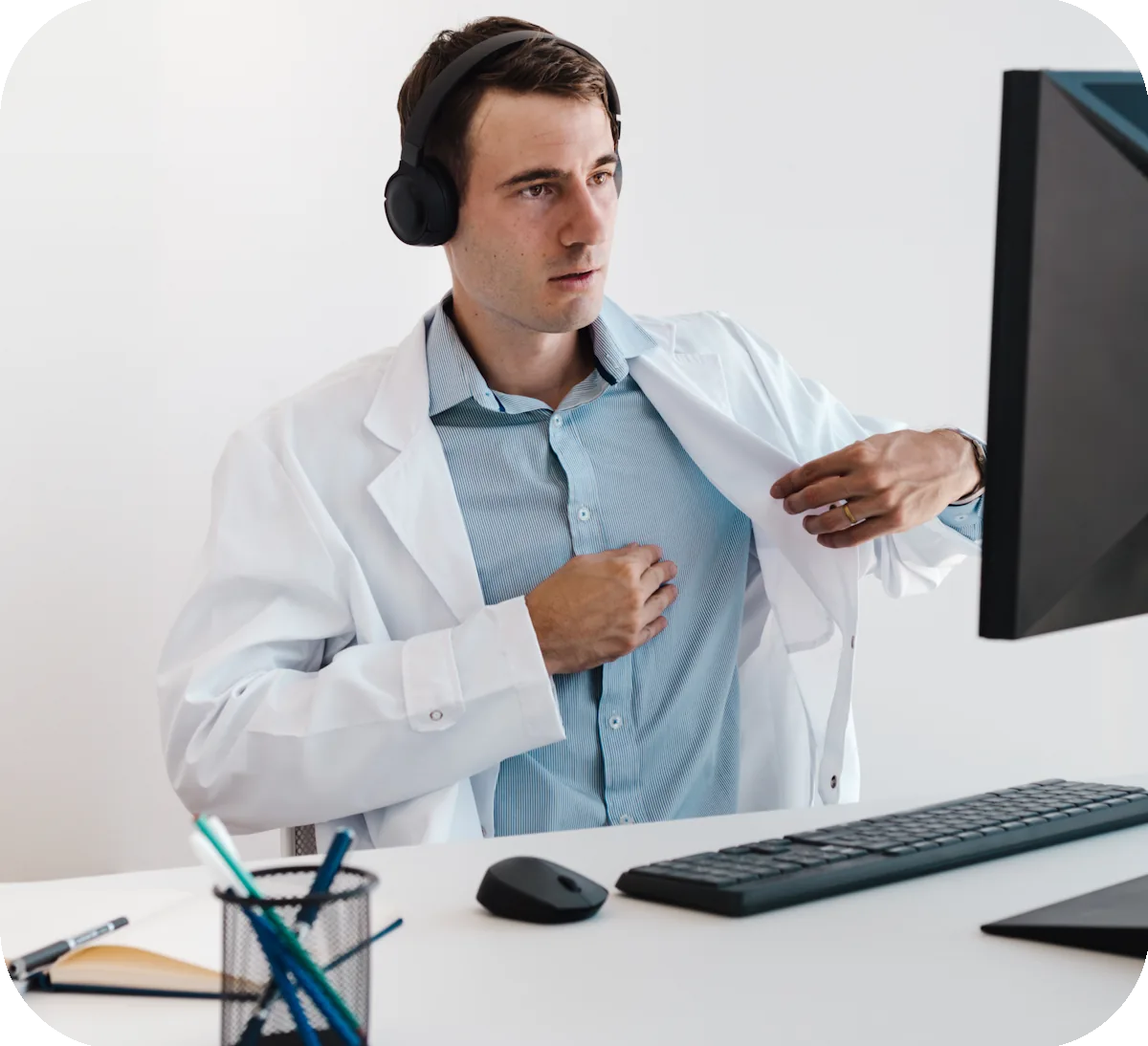 Un médico con auriculares revisa una consulta en un monitor